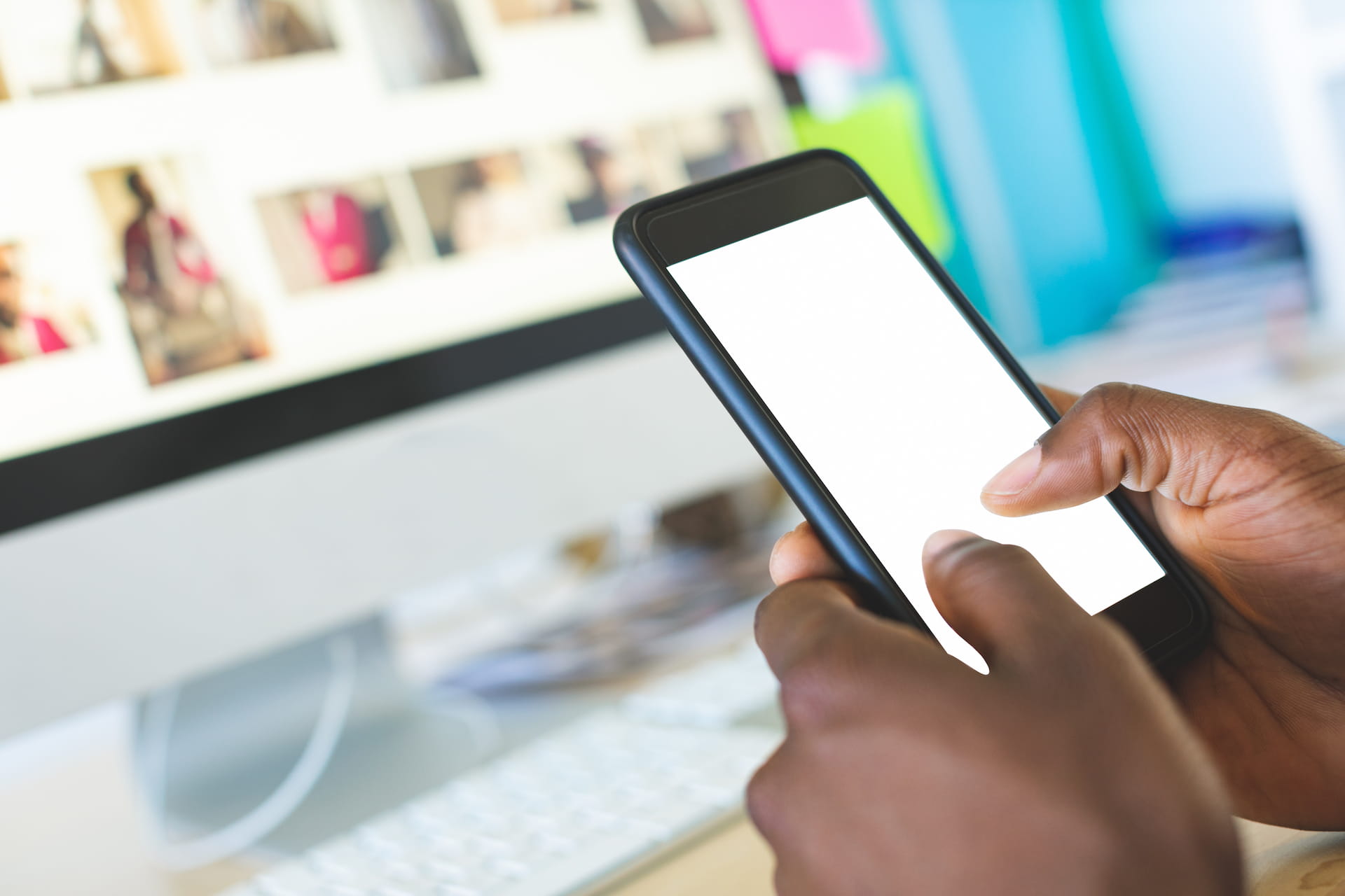 Business leader scrolling Instagram to hire virtual assistant on phone at desk