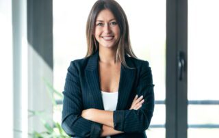 Confident company vice president standing with arms crossed in a modern office setting