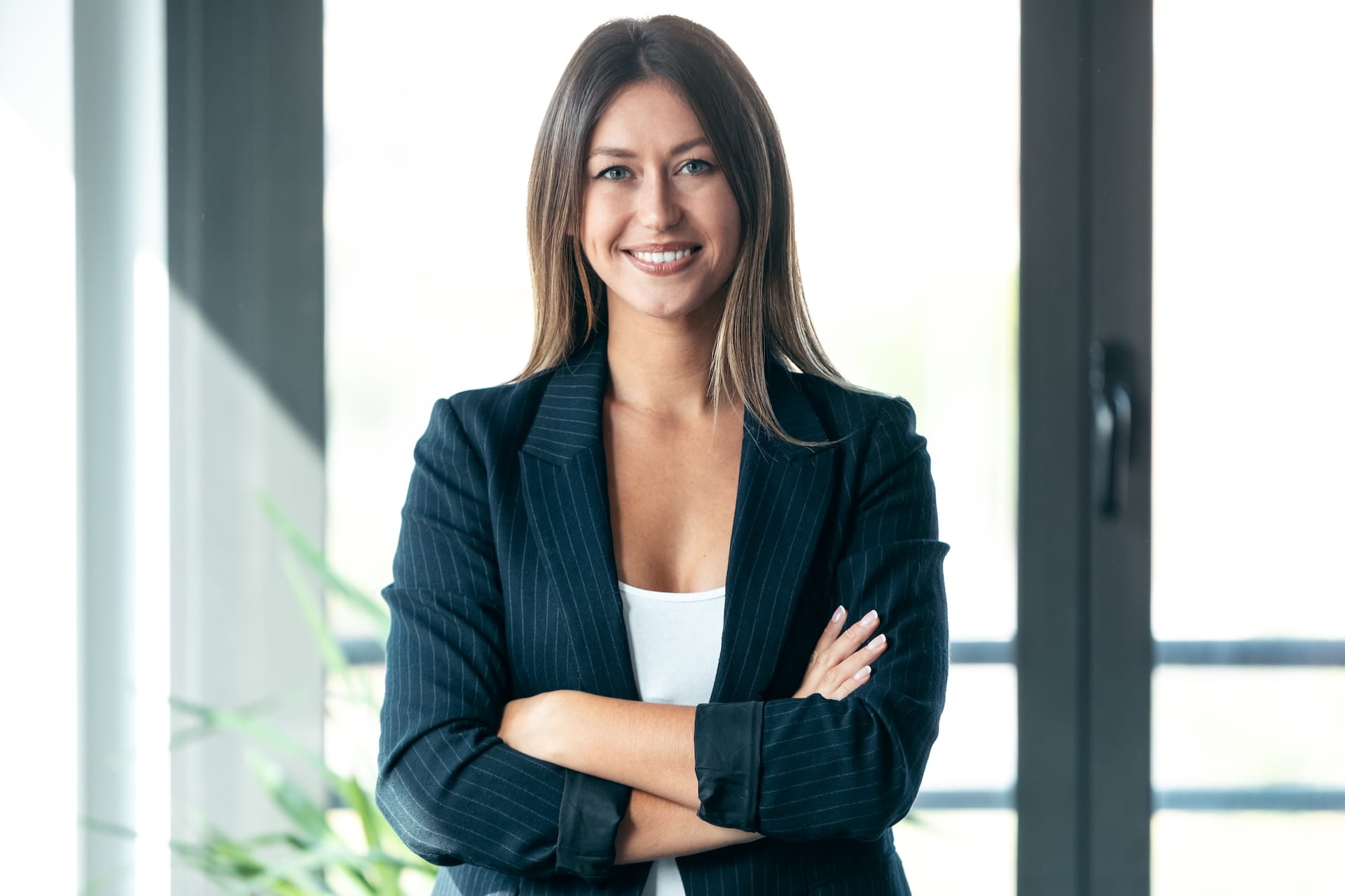 Confident company vice president standing with arms crossed in a modern office setting