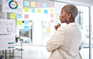 Option 1 (Direct): "Professional woman strategizing about delegating tasks to virtual assistants versus functions