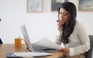 Professional businesswoman identifying virtual assistant red flags while reviewing hiring options at desk