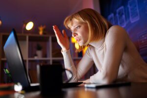 Frustrated businesswoman working late at computer dealing with generalist virtual assistant support issues