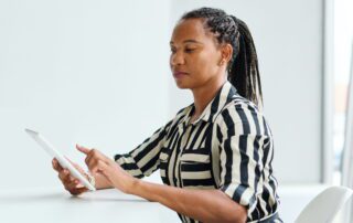 Business leader researching virtual assistants on Reddit on tablet in office