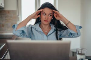 Frustrated business professional at laptop realizing her dedicated virtual assistant model isn't working