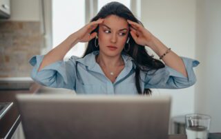 Frustrated business professional at laptop realizing her dedicated virtual assistant model isn't working