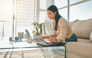 Professional accessing weekend virtual support while working from home office with laptop and planning materials